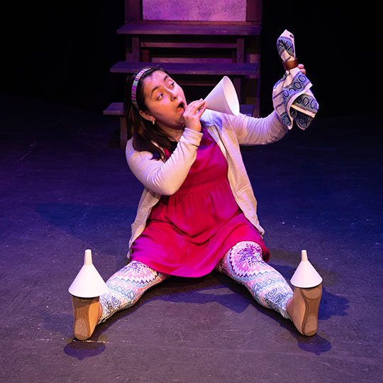 An actress on stage in Cenicienta: A Bilingual Cinderella
